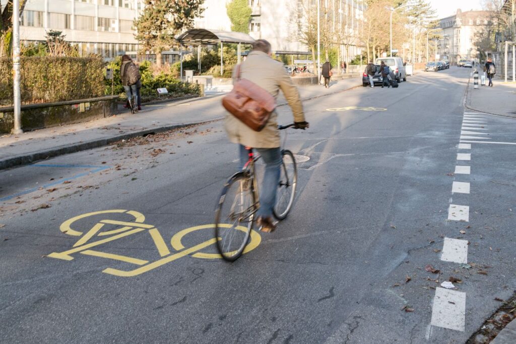 Mann mit Aktentasche fährt auf Fahrradstrasse