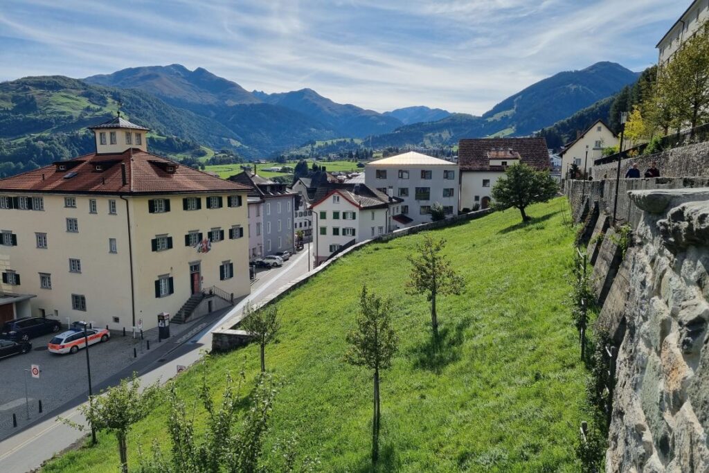 Vue sur Disentis et paysage avec montagnes et prairies