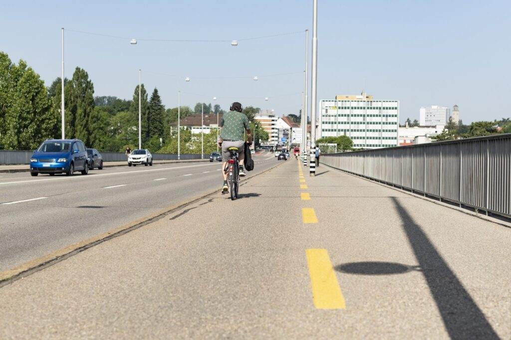 Le cycliste de dos traverse le pont vers la ville